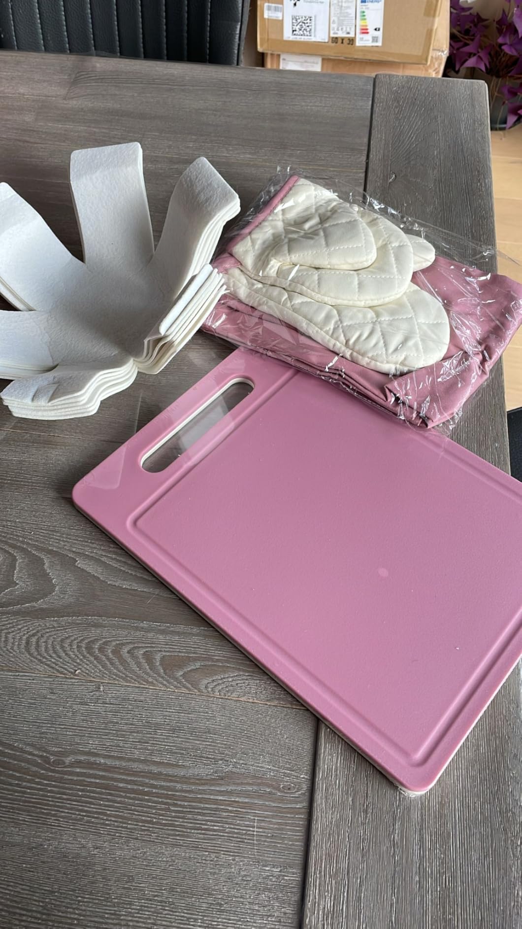 Pink chopping board with oven gloves